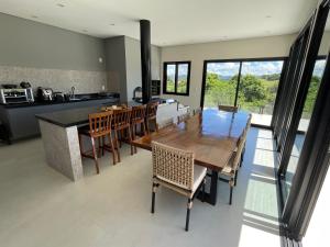 a kitchen and dining room with a wooden table and chairs at Casa represa Piracaia in Piracaia