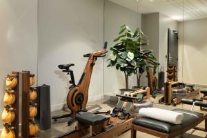 a room with a gym with exercise equipment and a mirror at Lyric Hotel Paris Opera in Paris