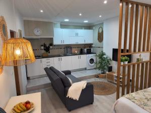 a kitchen and living room with a couch and a table at Lucas House in Nazaré
