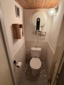 a small bathroom with a toilet with a phone on the wall at Romantický vejminek pod horami in Kounov +38 photos