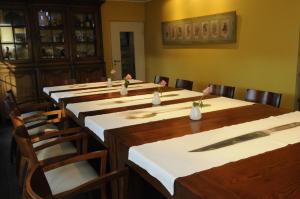 eine Reihe von Tischen in einem Raum mit Stühlen und einem Tischler in der Unterkunft Manoir Kasselslay in Clerf
