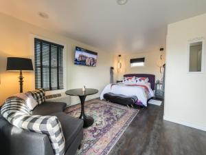 a bedroom with a bed and a couch and a table at EO Bungalows, Black Hills in Custer