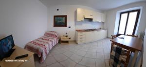 a kitchen with a bed and a table in a room at Affittacamere Ossola in Domodossola