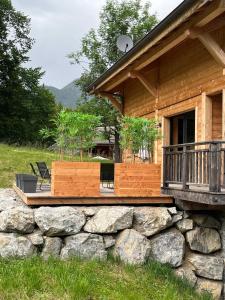 a log cabin with a porch and a stone wall at Chalet Frantz'y in Saint-Jean-d'Aulps