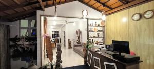 a living room with a couch and a television at Ras Rana Lodge in Rasdhoo