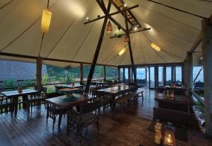 a restaurant with tables and chairs in a tent at Jeeva Beloam Beach Camp in Tanjung Ringgit