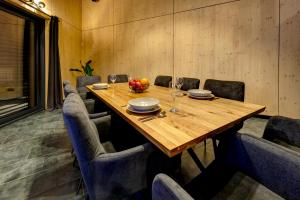 a dining room with a wooden table and chairs at TRIA House Liptov in Ižipovce