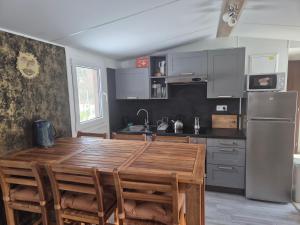 a kitchen with a wooden table and a refrigerator at Sauna v lese in Uhrovec