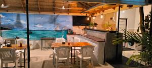 a restaurant with tables and chairs and a view of the ocean at Ras Rana Lodge in Rasdhoo