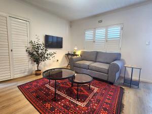 a living room with a couch and a table at Welgelegen Self Catering in Malmesbury +8 photos