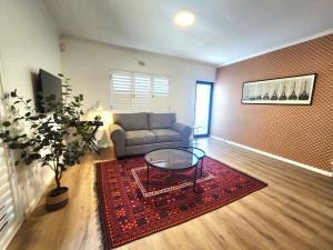 a living room with a couch and a glass table at Welgelegen Self Catering in Malmesbury