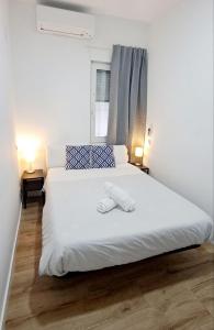 a bedroom with a bed with white sheets and a window at AYZ Joaquín Pol - Auto check-in property in Madrid