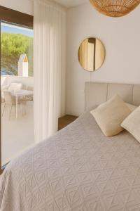 a bedroom with a bed and a mirror and a table at Casabaja in Baja Sardinia