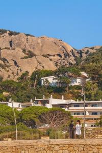 two people standing on a fence in front of a building at Casabaja in Baja Sardinia