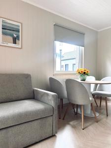 a living room with a couch and a table at Szarotka Łeba - nowe domki blisko plaży in Łeba