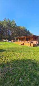 a house in the middle of a grass field at Sauna v lese in Uhrovec +8 photos