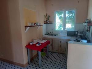 a kitchen with a red table and a sink at Chez Caze Maman in Crève Coeur