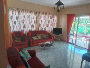 a living room with two red couches and a television at Chez Caze Maman in Crève Coeur