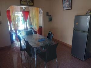 a kitchen with a table and chairs and a refrigerator at Chez Caze Maman in Crève Coeur