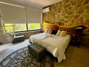 a bedroom with a bed and a stone wall at Airam, Holistic Boutique Hotel in Tequesquitengo +59 photos