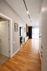 an empty room with a hallway with a hard wood floor at Leo Lux 2 in Niš +42 photos