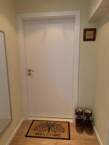 a white door with a welcome mat in front of it at Chamkoria Forest apartment in Borovets +24 photos