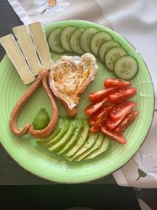 a green plate of food with eggs and vegetables at Villa Gabino in Balatonberény