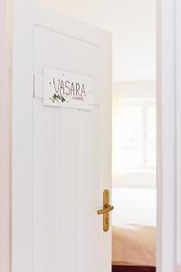 a white door with a sign on it at Villa Kurorto Namas in Druskininkai