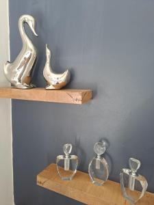 a shelf with three glass vases on it at Boutique Inn - Azure in Gordonʼs Bay