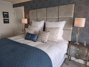 a bedroom with a large bed with pillows at Boutique Inn - Azure in Gordonʼs Bay