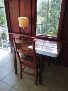 a wooden table with a chair and a lamp on it at Maison tranquille in Rivas