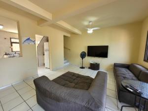 a living room with a couch and a flat screen tv at Lar no Atami com piscina aquecida in Pontal do Paraná
