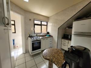 a kitchen with a stove and a table in it at Lar no Atami com piscina aquecida in Pontal do Paraná
