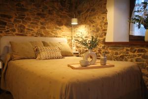 a bedroom with a bed with a stone wall at MINI PICONEIRO II in Pravia