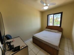 a small bedroom with a bed and a window at Lar no Atami com piscina aquecida in Pontal do Paraná +39 photos