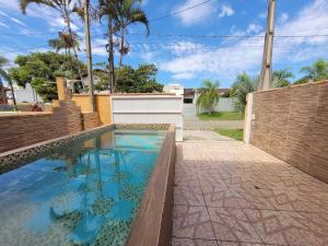 a swimming pool in a backyard with a fence at Lar no Atami com piscina aquecida in Pontal do Paraná