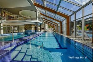 ein Schwimmbad in einem Gebäude mit Glasdecke in der Unterkunft Spa hotel Lanterna in Velké Karlovice