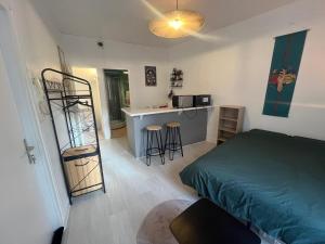 a small bedroom with a bed and a kitchen at Studio meublé centre-ville Saint Junien in Saint-Junien