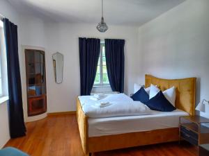 a bedroom with a large bed with blue pillows at Ferienwohnung 'Bergidylle' - Zu Fuß auf die Loipe und den Berg, nur wenige Minuten ins Skigebiet in Bayrischzell