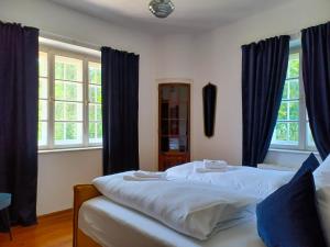 a bedroom with two beds with blue curtains at Ferienwohnung 'Bergidylle' - Zu Fuß auf die Loipe und den Berg, nur wenige Minuten ins Skigebiet in Bayrischzell