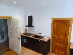 a kitchen with a sink and a stove and a door at Ferienwohnung 'Bergidylle' - Zu Fuß auf die Loipe und den Berg, nur wenige Minuten ins Skigebiet in Bayrischzell +11 photos