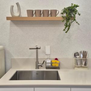 a kitchen counter with a sink and a shelf at 포포스테이 in Busan