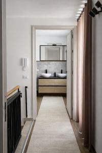 a hallway with a bathroom with two sinks and a mirror at CASA NO-MA in centro storico in Marsala