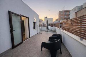 a balcony with two chairs on a building at CASA NO-MA in centro storico in Marsala