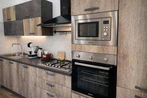 a kitchen with a stove and a microwave at CASA NO-MA in centro storico in Marsala