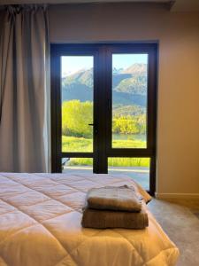 a bedroom with a bed and a large window at Límite Sur Lodge in Trevelín