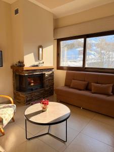 a living room with a couch and a fireplace at Austria Luxury Apartments, Faraya Hotel in Fārayyā