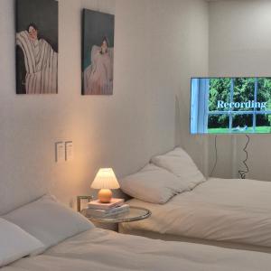 a room with two beds and a tv on the wall at 포포스테이 in Busan
