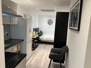 a room with a kitchen and a bedroom with a bed at Modern Studio flat with free parking in Langley Marish