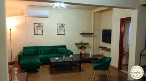a living room with a green couch and a table at Anastasia's Apartment ΛΑΥΡΙΟ in Lavrio